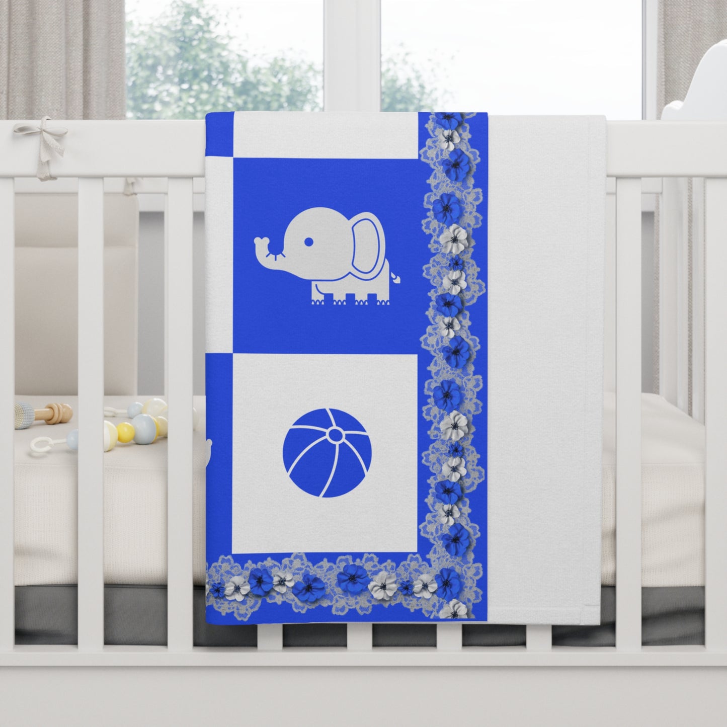 Blue crib sheet with elephant and ball design on a white crib