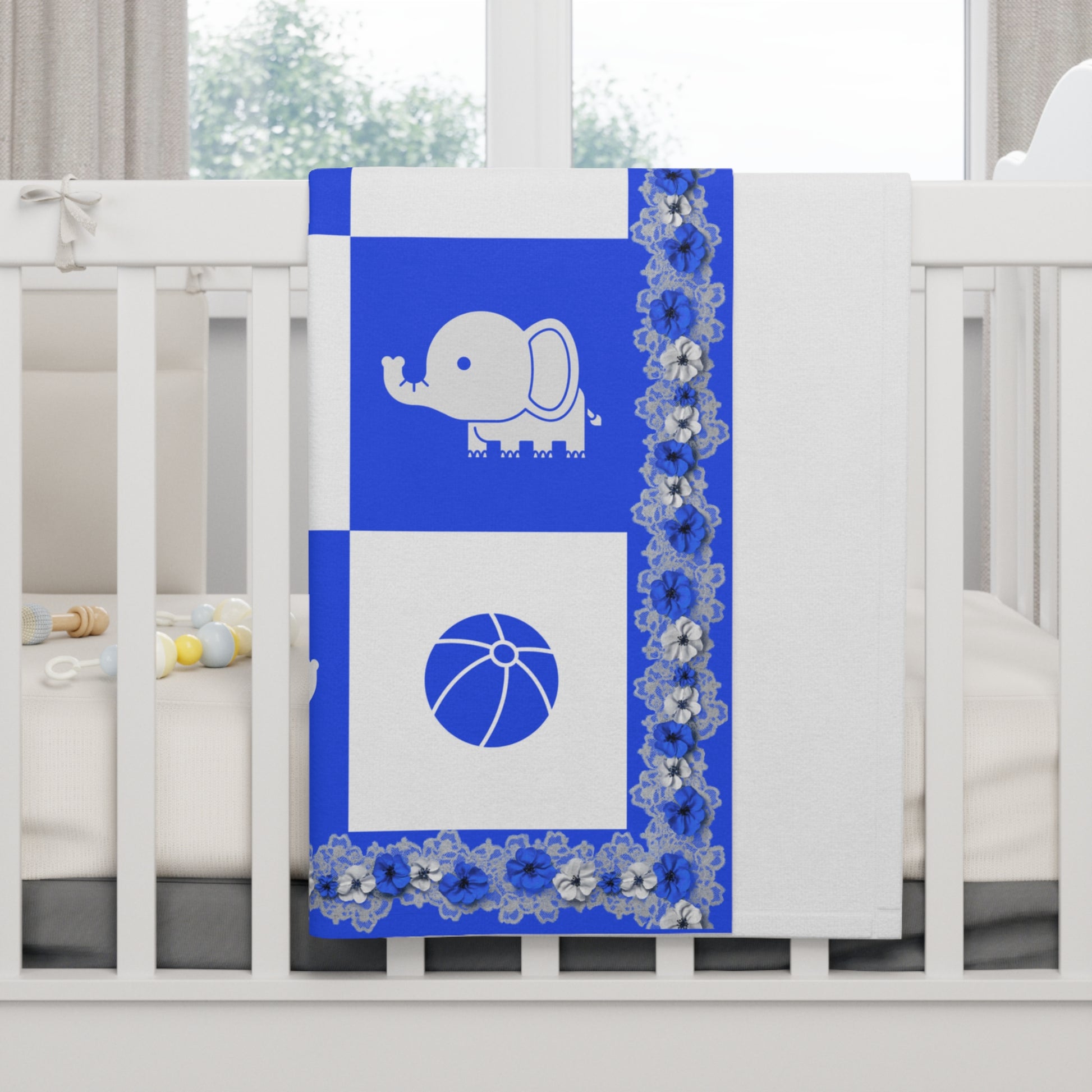 Blue crib sheet with elephant and ball design on a white crib